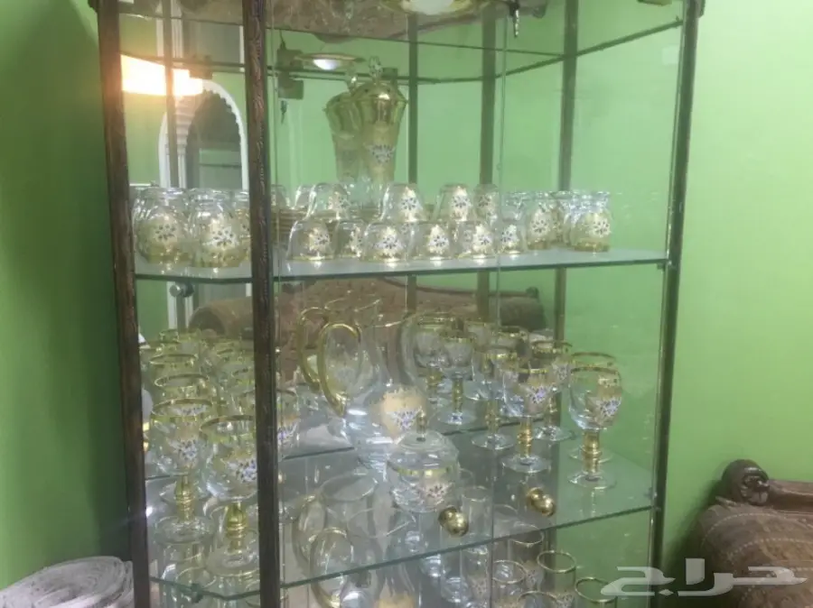 دولاب زجاجي مع طقم شاي وقهوة مذهب