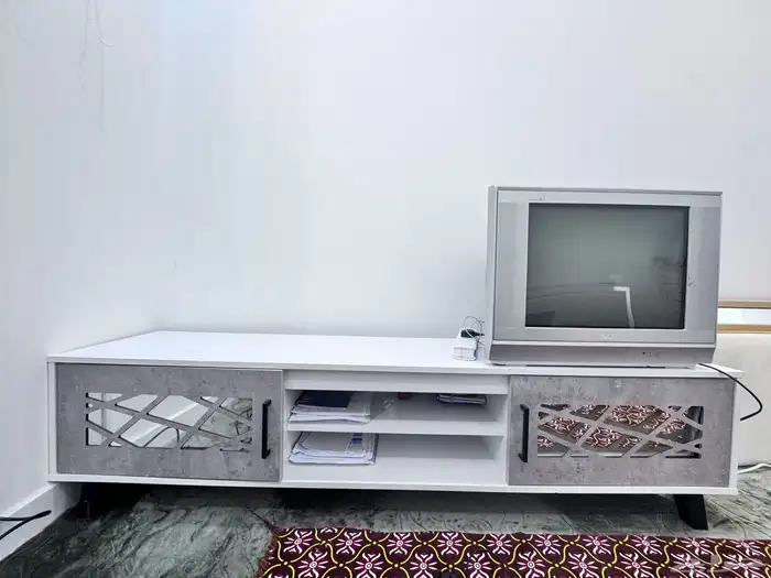 طاولة تلفزيون جديده وشاشه بلاستيشن فيها خط بالشاشه بسيط 1