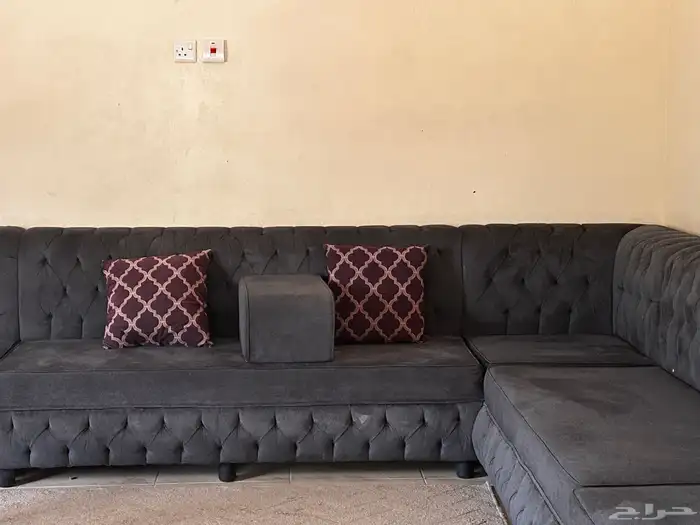 كنب متصل واسع لونه رمادي فحمي معاه أربع مراكي وثمان مخاد 0