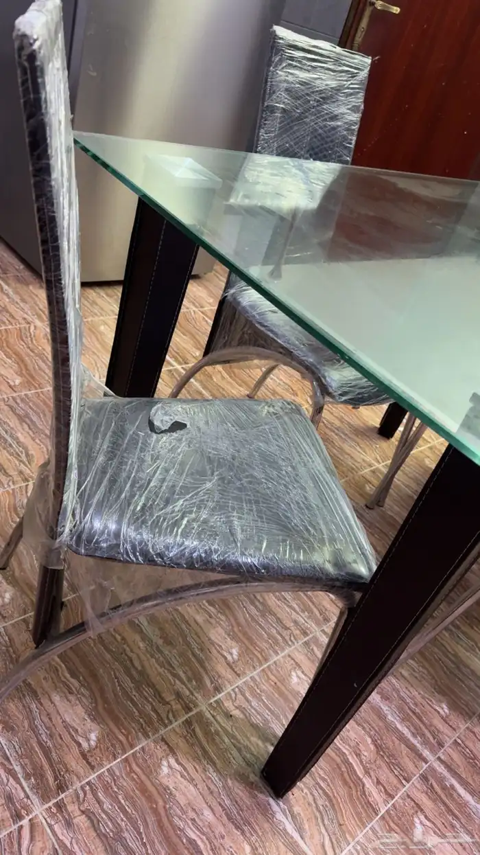 طاولة طعام زجاج و 4 كراسي جلد نظيفه وجديده والكراسي مغلفه 1