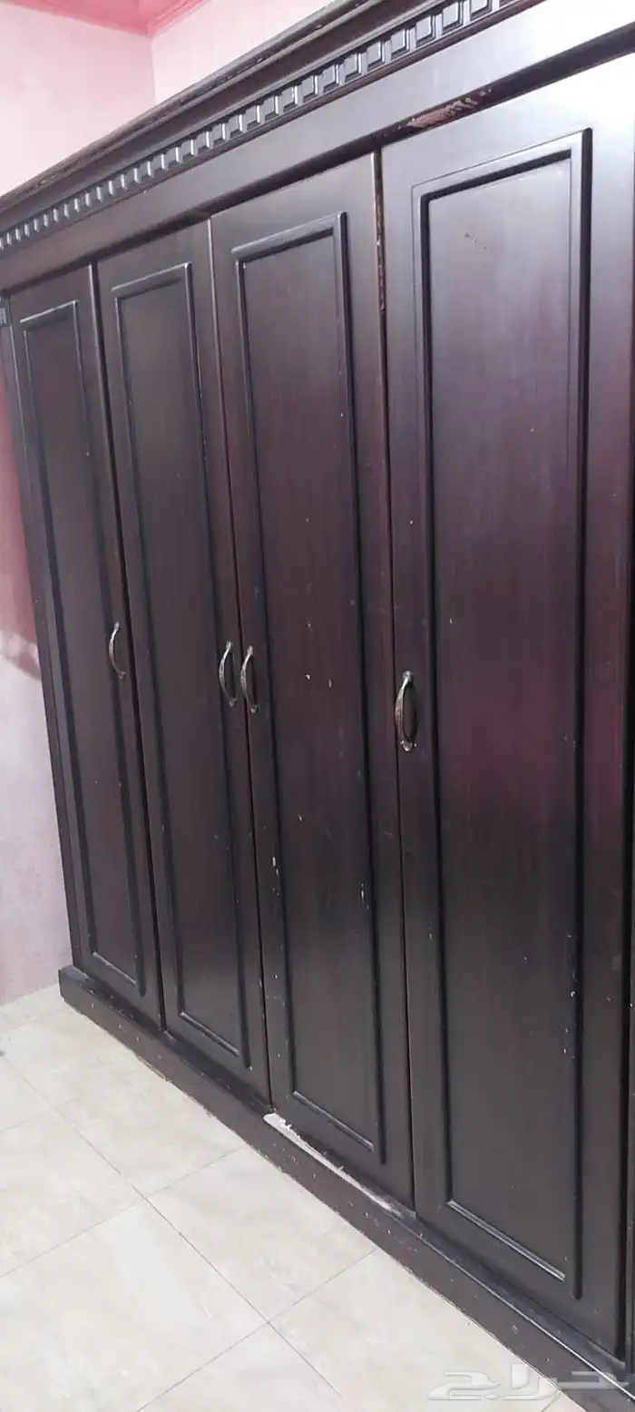 غرفة مكونة من سرير ودولاب كمدينة وكرسي 0